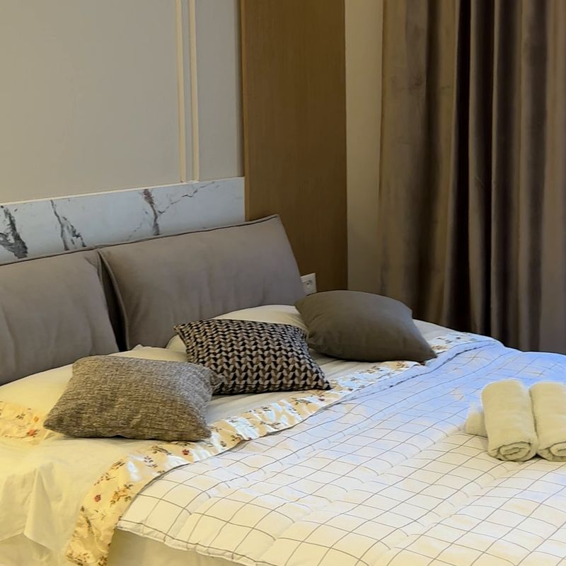 Camera da letto con letto matrimoniale e asciugamani puliti, in una sistemazione a Tirana