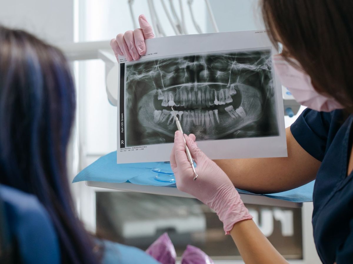 Una dentista mostra a una paziente la radiografia panoramica