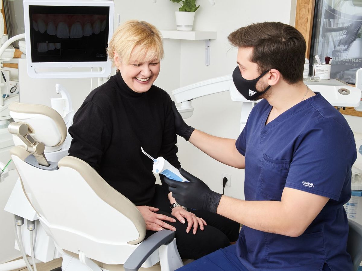 Una paziente sorridente sulla poltrona del dentista